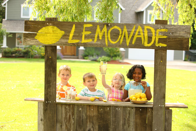  Four children operating a lemonade stand.