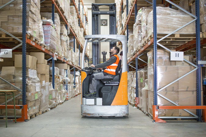 An employee operating a fork lift at a distribution warehouse.