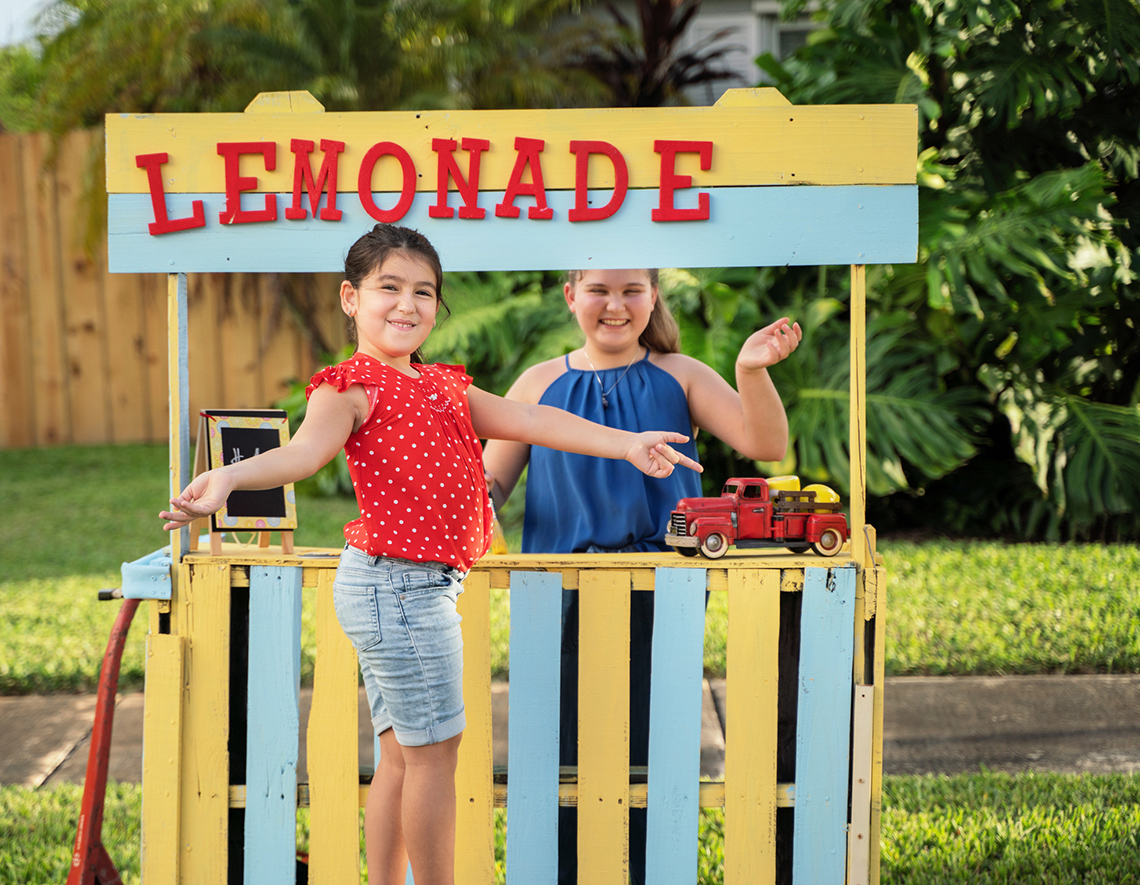 Two children running a homemade lemonade stand.